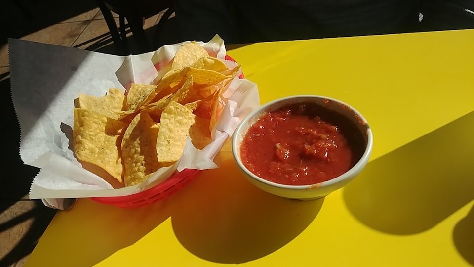 Close view of a menu with tacos and sopes.
